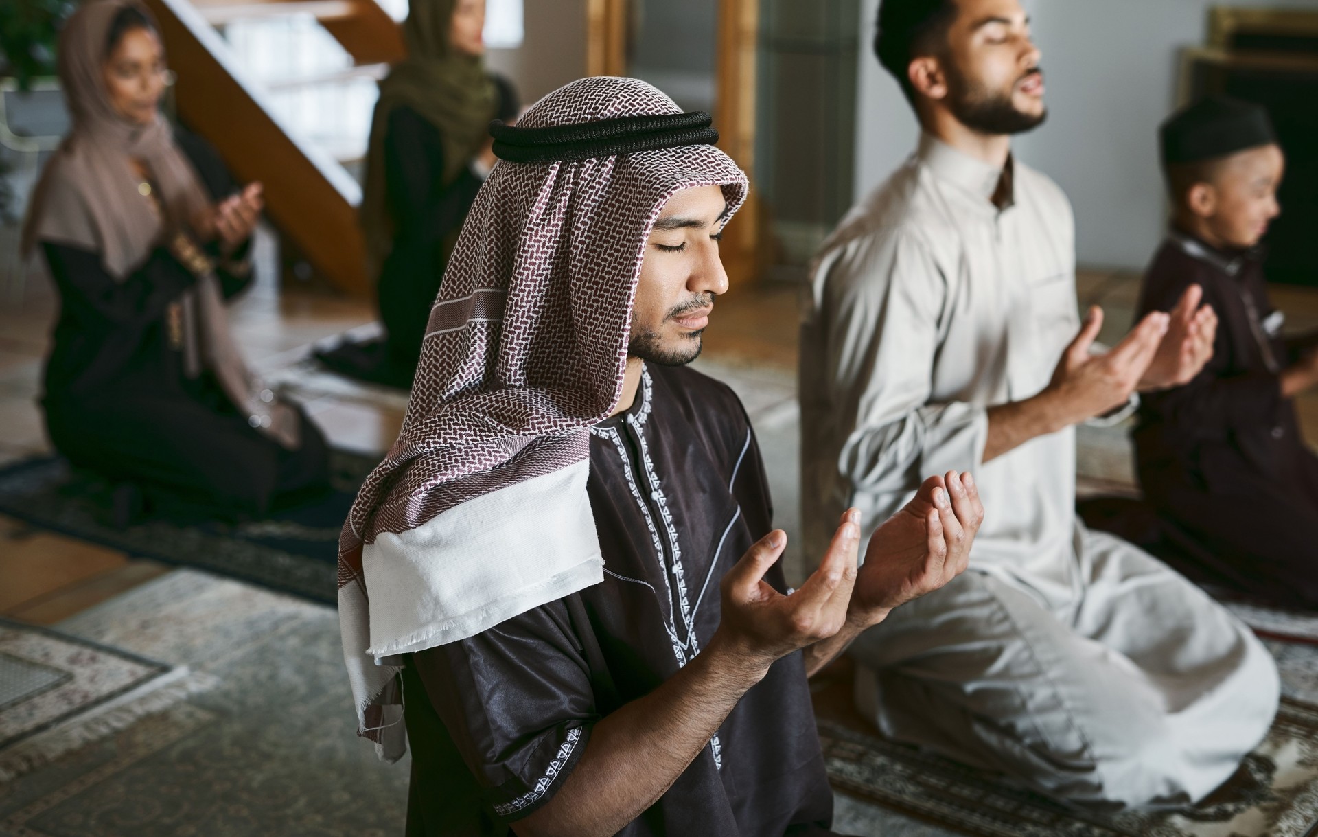 Shot of a group of muslim family members praying together
